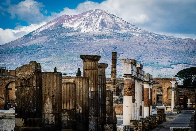 The snow-covered peak of Mount Vesuvius volcano is seen from the streets of the archaeological site in Pompeii, near Naples, southern Italy, 15 February 2021. Snow and icy winds continued to whip Italy on 15 February with wintry weather that has been brought to the region by a Siberian cold front. (Photo by Cesare Abbate/EPA/EFE)
