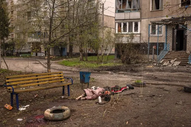 The body of a civilian killed during heavy Russian shelling of a residential neighbourhood lies next to a park bench on April 19, 2022 in Kharkiv, Ukraine. According to preliminary reports four people were killed and 21 injured in the bombardment. Russia began the “next phase” of its military offensive into eastern Ukraine with intensified missile attacks, shelling, and tank movements across the countries eastern cities and towns. (Photo by Chris McGrath/Getty Images)
