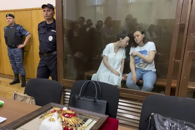 Zhenya Berkovich, a prominent independent theater director, left, and Svetlana Petriychuk, a playwright, sit in a cage prior to a hearing in a court in Moscow, Russia, on Friday, June 30, 2023. A Russian court on Friday ordered pretrial detention for a theater director and a playwright facing charges of justifying terrorism, the latest move in a relentless crackdown on dissent in Russia that spiked to unprecedented levels since the start of the war in Ukraine. (Photo by Vladimir Kondrashov/AP Photo)