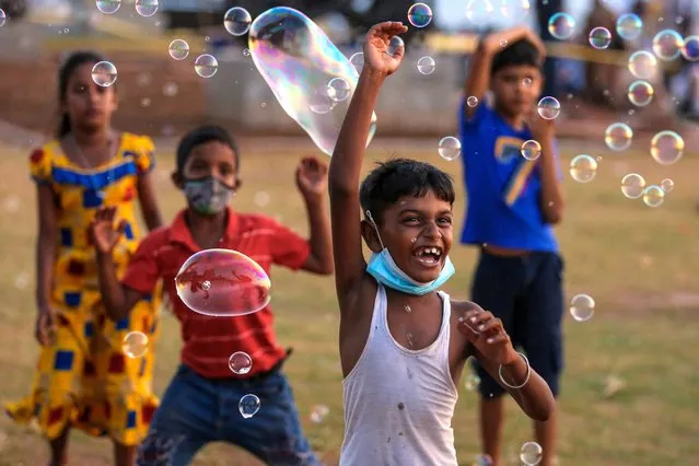 Sri Lankan children's play with soap bubbles at the Galle Face sea promenade in Colombo, Sri Lanka, 14 February 2021. (Photo by Chamila Karunarathne/EPA/EFE)