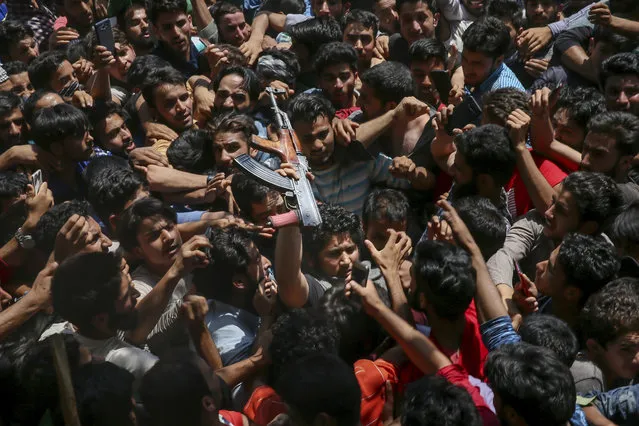 Kashmiri villagers stretch out their hands to touch a Pakistani rebel, as a mark of respect, as he arrives at a funeral to pay tributes to slain rebels Umar Malik and Wakar Sheikh in Malikgund village, south of Srinagar, Indian controlled Kashmir, August 4, 2018. At least seven rebels and an Indian army soldier were killed in gunbattles in disputed Kashmir, triggering violent protests by residents opposed to Indian rule, officials said Saturday. (Photo by Dar Yasin/AP Photo)