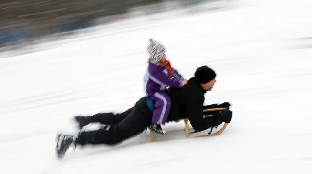 A man and child ride a sledge after heavy snowfall in Berlin, Germany, January 6, 2016. (Photo by Hannibal Hanschke/Reuters)