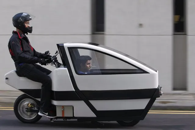 Members of the TUM CREATE group ride a prototype of their VOI scooter at the Nanyang Technological University (NTU) in Singapore May 28, 2013. The electric-powered VOI multipurpose scooter was designed to provide the ease of mobility and affordability of a scooter while offering car-like comfort and protection to the passenger. TUM CREATE is a joint research programme between Germany's Technische Universitat Munchen (TUM) and the NTU. The group is looking to further develop the prototype. (Photo by Edgar Su/Reuters)