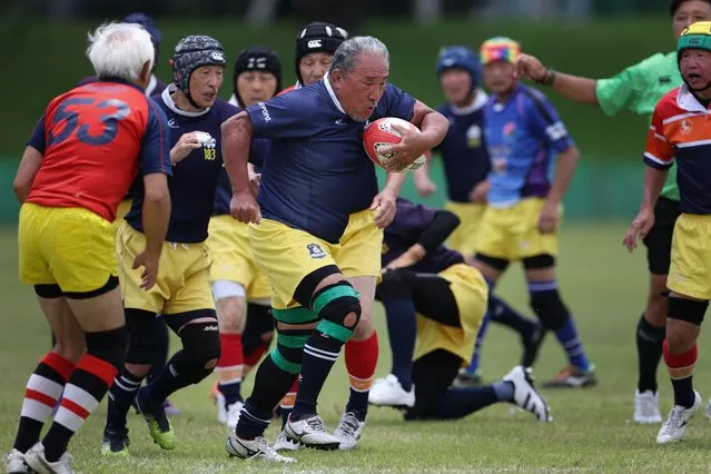 This photo taken on June 25, 2023 shows Fuwaku rugby club players taking part in a rugby union match between two seniors over 70s teams at the Tochigi Prefectural Sports Park in the city of Utsunomiya, Tochigi prefecture. The Fuwaku rugby club was created in 1979. They have different colors of shorts depending on their age: white shorts are for those in their forties, blue for the fifties, red for the sixties, yellow for the seventies, purple for the eighties and gold for the nineties. It is one of approximately 150 Japanese clubs that stages competitive full-contact matches for players over the age of 40. Ahead of the Rugby World Cup in France, Agence France-Presse asked aspiring photographers from countries qualified for the competition to show one aspect of the rugby union culture in their homeland, with the help of Canon cameras who are sponsoring the tournament. From Namibia to Fiji via Romania to Portugal this photo essay gives us a glimpse of the core values of rugby on five continents. (Photo by Karen Haibara/AFP Photo)