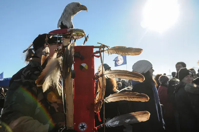 A man carrying a “Turtle Island struggle eagle staff” stands in Oceti Sakowin camp as “water protectors” continue to demonstrate against plans to pass the Dakota Access pipeline near the Standing Rock Indian Reservation, near Cannon Ball, North Dakota, U.S. December 4, 2016. (Photo by Stephanie Keith/Reuters)