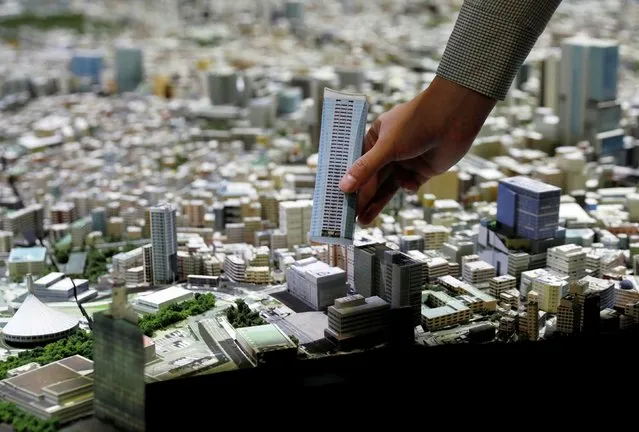 Staff of Mori Building adds a new miniature of a building on a 1:1000 scale version of Tokyo at a photo opportunity at Mori Building Urban Lab in Tokyo, Japan, April 26, 2021. (Photo by Kim Kyung-Hoon/Reuters)