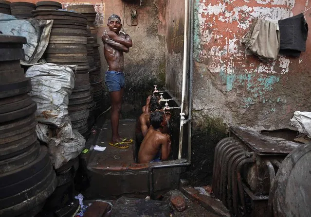 Boys bathe at roadside municipal taps during early morning in the old quarters of Delhi February 17, 2015. (Photo by Ahmad Masood/Reuters)