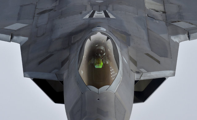 A pilot looks up from a U.S. F-22 Raptor fighter as it prepares to refuel mid-air with a KC-135 refuelling plane during a flight to Britain from Mihail Kogalniceanu air base in Romania, April 25, 2016. (Photo by Toby Melville/Reuters)