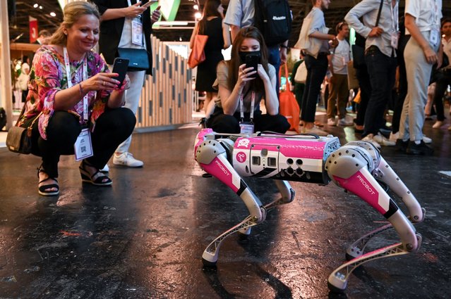 Attendees watch a robot demonstration at the Vivatech technology startups and innovation fair in Paris on May 15, 2022. (Photo by Bertrand Guay/AFP Photo)