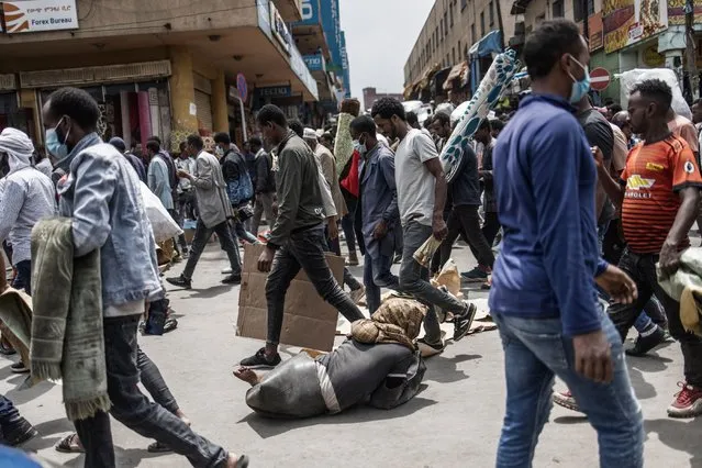 A beggar negotiates his way against a crowd of Muslim worshippers leaving a mosque after the Friday prayer in the historical Merkato area of Addis Ababa on June 11, 2021. Most of Ethiopia is heading to the polls on June 21 for the 547 seats in Ethiopia's House of Representatives, while  some regions will hold the sixth general election on September 6, according to the National Electoral Board of Ethiopia. (Photo by Marco Longari/AFP Photo)