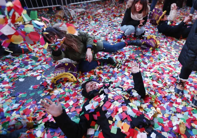 Revelers throw confetti on themselves after after celebrating the new year in Times Square, Sunday, January 1, 2017, in New York. (Photo by Julio Cortez/AP Photo)