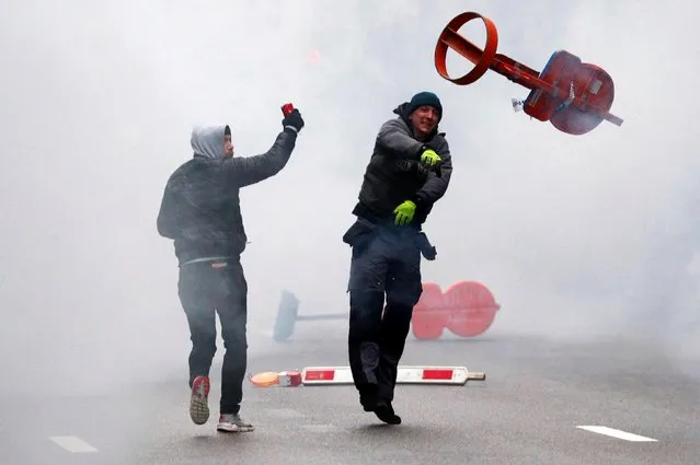Far-right supporter throws a traffic sign during a protest against Marrakesh Migration Pact in Brussels, Belgium December 16, 2018. (Photo by Francois Lenoir/Reuters)