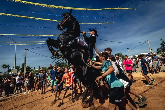 A “caixer” (horse rider) rears up on his horse surrounded by a cheering crowd during the traditional “Jaleo” at the annual festival in Cala En Porter, Spain on September 18, 2022. (Photo by Matthias Oesterle/Rex Features/Shutterstock)