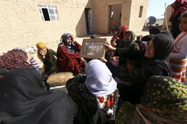 Women morn the death of a relative killed by Islamic State fighters while carrying his picture in Mteahh village near al-Shadadi town, Hasaka countryside Syria February 18, 2016. (Photo by Rodi Said/Reuters)