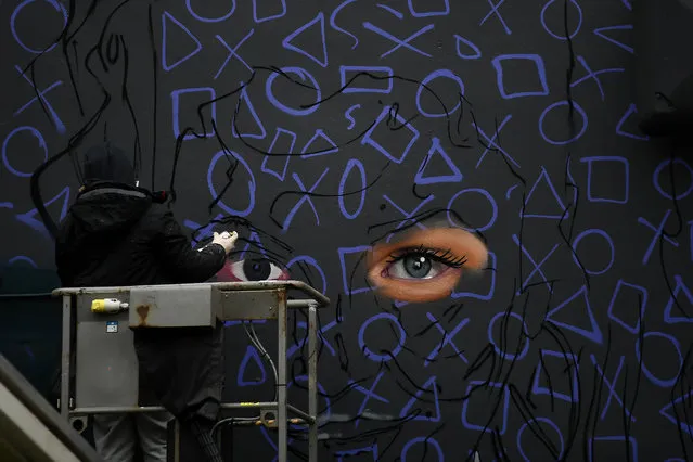 Graffiti artist spray paints a new mural of “Derry Girls” television show in Londonderry, Northern Ireland, January 25, 2019. (Photo by Clodagh Kilcoyne/Reuters)