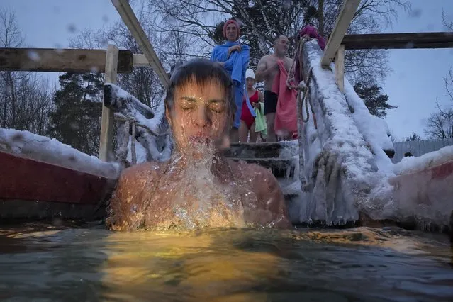 A Russian Orthodox believer dips in the icy water during a traditional Epiphany celebration, in St. Petersburg, Russia, Friday, January 19, 2024. Thousands of Russian Orthodox Church followers plunged into icy rivers and ponds across the country to mark Epiphany, cleansing themselves with water deemed holy for the day. The temperature in St.Petersburg is –4 Celsius (24 Fahrenheit). (Photo by Dmitri Lovetsky/AP Photo)