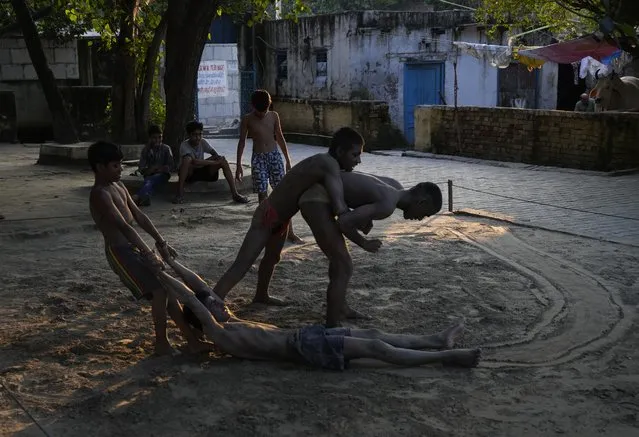 Children play and wrestle on a ghat of the river Yamuna in New Delhi, India, Wednesday, September 29, 2021. (Photo by Manish Swarup/AP Photo)