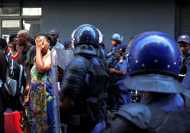 A woman reacts after police officials evicted a group of people from a building which they had illegally occupied, in Cape Town, South Africa on January 24, 2024. (Photo by Esa Alexander/Reuters)