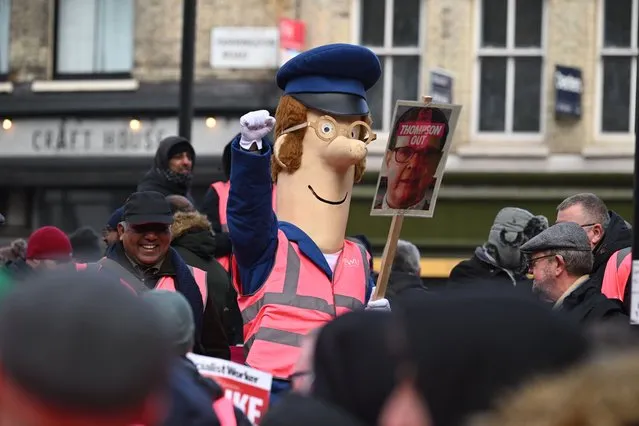 A demonstrator dresses as Postman Pat as striking mail workers and supporters march to Parliament Square on December 9, 2022 in London, England. Royal Mail workers are staging strikes throughout December in an escalating row over pay, jobs and conditions. (Photo by Leon Neal/Getty Images)