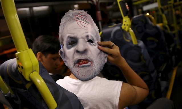 A demonstrator inside a bus wears a mask depicting Brazil's former president Luiz Inacio Lula da Silva after a protest against Brazil's President Dilma Rousseff, which is part of nationwide demonstrations calling for her impeachment, in Sao Paulo, Brazil, March 13, 2016. (Photo by Nacho Doce/Reuters)
