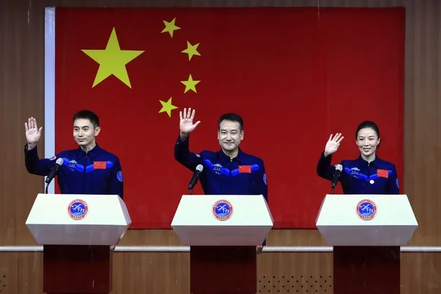 In this photo released by Xinhua News Agency, Chinese astronauts, from left, Ye Guangfu, Zhai Zhigang and Wang Yaping wave to reporters as they arrive for a press conference at the Jiuquan Satellite Launch Center ahead of the Shenzhou-13 launch mission from Jiuquan in northwestern China, Thursday, October 14, 2021. China is preparing to send three astronauts to live on its space station for six months – a new milestone for a program that has advanced rapidly in recent years. (Photo by Ju Zhenhua/Xinhua via AP Photo)