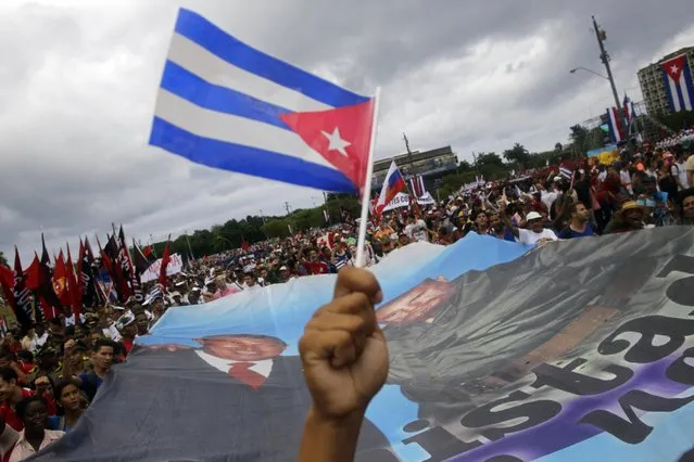 Cubans hold a a banner with an image of the late Venezuelan President Hugo Chavez and Cuban leader Fidel Castro, as they march in Revolution Square marking May Day, in Havana, Cuba, Friday, May 1, 2015. (Photo by Ramon Espinosa/AP Photo)