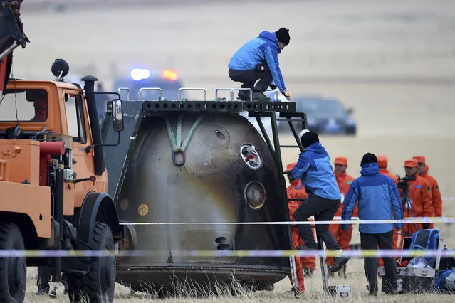 In this photo released by Xinhua News Agency, ground crew check on the re-entry capsule of Shenzhou 11 spacecraft after it landed in north China's Inner Mongolia Autonomous Region, Friday, November 18, 2016. (Photo by Ren Junchuan/Xinhua via AP Photo)