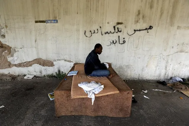 A Sudanese immigrant is seen inside a deserted textile factory in the western Greek town of Patras April 28, 2015. (Photo by Yannis Behrakis/Reuters)
