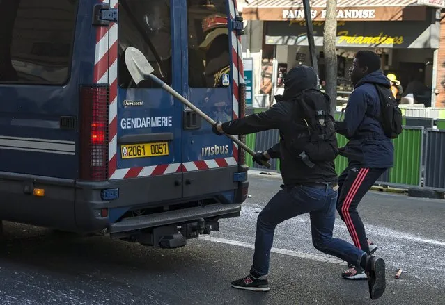 Youths attack a riot police van with a shovel as they take part in a demonstration against the government's controversial labor reform, in Paris, France, 17 March 2016. French students are protesting against a draft of the French government on new labor laws. (Photo by Etienne Laurent/EPA)