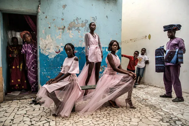 Portraits, singles winner: Dakar fashion, by Finbarr O’Reilly. Curious residents and a street vendor selling material look on as models Diarra Ndiaye, Ndeye Fatou Mbaye and Malezi Sakho wear outfits by the Senegalese designer Adama Paris in the Medina neighbourhood of Senegal’s capital, Dakar. (Photo by Finbarr O’Reilly/World Press Photo 2019)