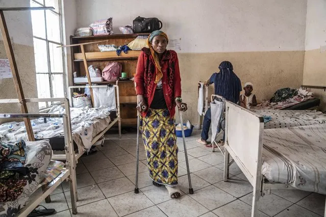 A woman who was wounded in ongoing fighting between M-23 rebel forces and Congolese forces in the Sake region West of Goma, eastern Congo, stands on crutches by her hospital bed in Goma, Tuesday, February 13, 2024. In recent days, main roads around Goma and Sake, routes that are crucial for the movement of civilians, goods, and humanitarian aid, have become impassable due to intensified fighting, further restricting access to essential services and supplies said humanitarian aid organisation, Mercy Corps. (Photo by Moses Sawasawa/AP Photo)