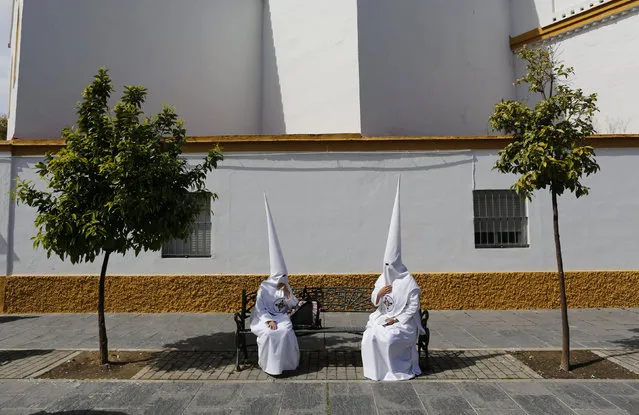 Penitents of San Gonzalo brotherhood sit as they wait to take part in a Holy Week procession in the Andalusian capital of Seville, southern Spain March 21, 2016. (Photo by Marcelo del Pozo/Reuters)