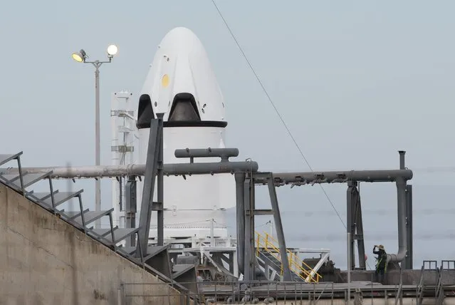 A SpaceX worker stands near the unmanned SpaceX Crew Dragon as it sits on launch pad 40 before a Pad Abort Test at the Cape Canaveral Air Force Station in Cape Canaveral, Florida May 5, 2015. (Photo by Scott Audette/Reuters)