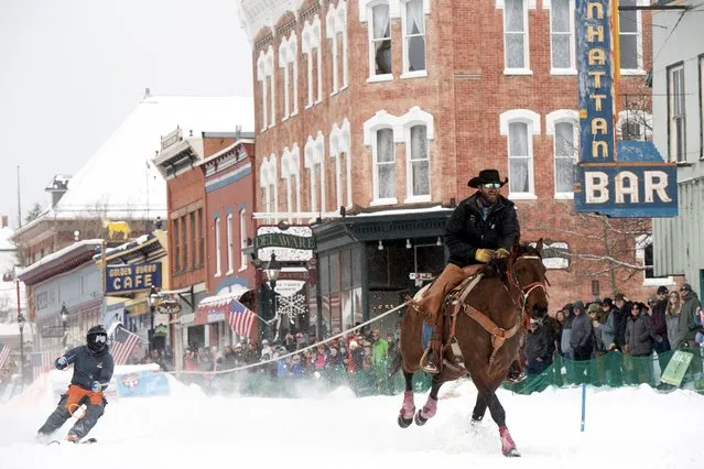 A rider pulls a skier down Harrison Avenue during the 76th annual Leadville Ski Joring weekend competition on March 3, 2024 in Leadville, Colorado. Skijoring, which has its origins as a competitive sport in Scandinavia, has been adapted over the years to include a team made up of a rider and skier who must navigate jumps, slalom gates and the spearing of rings for points. Leadville, with an elevation of 10,152 feet (3,094 m), the highest incorporated city in North America, has been hosting skijoring competitions since 1949. (Photo by Jason Connolly/AFP Photo)