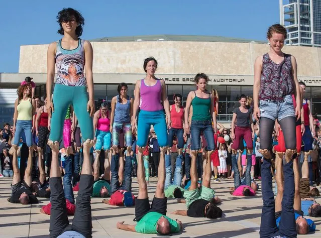 Israelis take part in a large acro-yoga flashmob on March 11, 2016 on Habima Square, in the coastal city of Tel Aviv. Some 150 people took part in the event. (Photo by Jack Guez/AFP Photo)