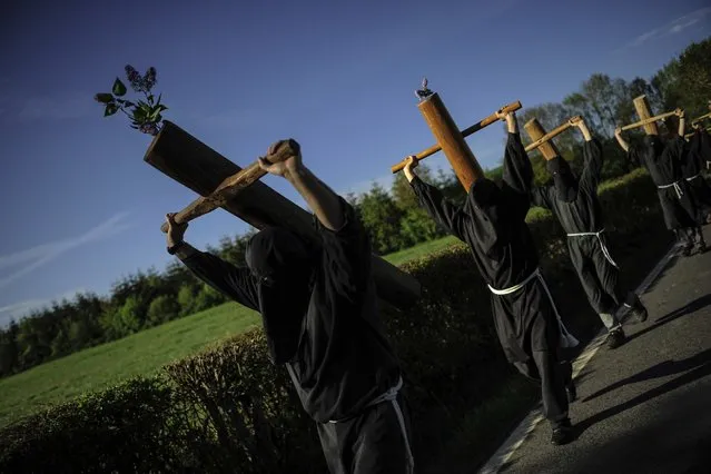 Masked penitents holds their crosses  during spring “Romeria Cruceros de Arce”, while they walk alongside Villanueva de Arce and Roncesvalles northern Spain Sunday, May 10, 2015. Every year on the second Sunday in spring, people with crosses march from their small Pyrenees towns to Roncesvalles Church in tribute of the Virgin. (Photo by Alvaro Barrientos/AP Photo)