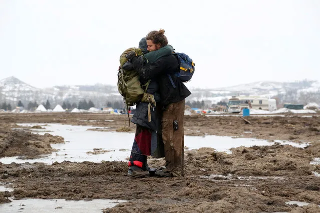Susanna Travis (left), from Grass Valley, California, embraces Timothy Powers, also from California, before evacuating the main opposition camp against the Dakota Access oil pipeline near Cannon Ball, North Dakota, U.S., February 23, 2017. (Photo by Terray Sylvester/Reuters)