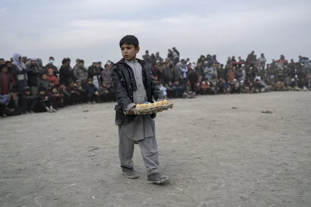 A boy sales eggs to spectators during wrestling matches in Kabul, Afghanistan, Friday, December 3 , 2021. (Photo by Petros Giannakouris/AP Photo)