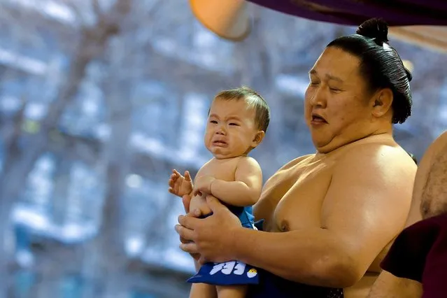 A sumo wrestler carries a baby before the “Honozumo” ceremonial sumo tournament at the Yasukuni Shrine in Tokyo April 3, 2015. (Photo by Thomas Peter/Reuters)