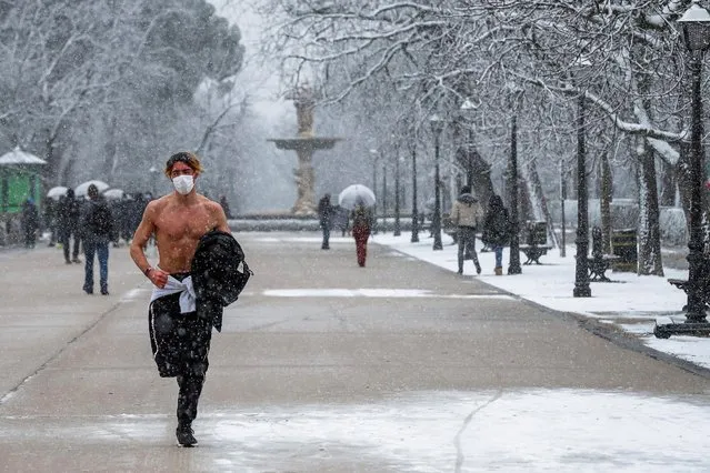 A shirtless runner excercises during a heavy snowfall at El Retiro Park, in Madrid, Spain, 07 January 2021. A warning has been issued across the country due to storm Filomena that has caused a big drop in temperatures and snowfalls throughout Spain, except for the Canary Islands. (Photo by Emilio Naranjo/EPA/EFE)