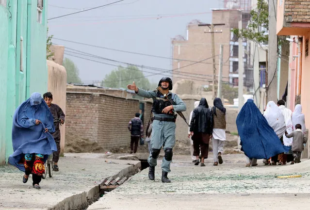 Security officials secure the area surrounding the Ministry of Defense during a gun battle with Taliban militants in Kabul, Afghanistan, 19 April 2016. At least 28 people were killed and another 327 wounded in a Taliban suicide attack in a high security zone in Kabul, where an explosion was followed by a clash between Afghan troops and insurgents. (Photo by Hedayatullah Amid/EPA)