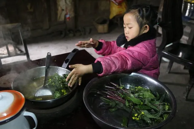 5-year-old Chinese girl Wang Anna feeds her great-grandmother at home in Zhuyuan village, Guizhou province, China on March 3, 2017. (Photo by Imaginechina/Rex Features/Shutterstock)