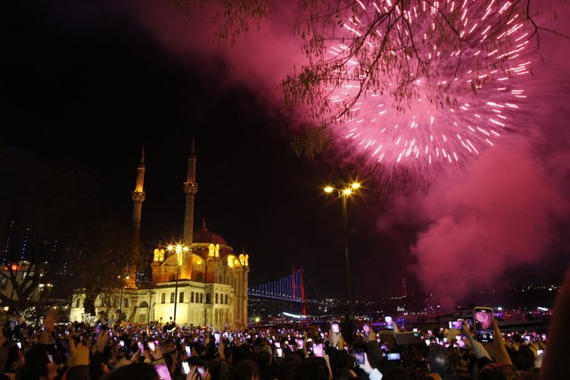 Fireworks explode over the Ottoman-era Mecidiye mosque in Ortakoy square next to “July 15th Martyrs” bridge, known as Bosphorus bridge, during New Year's Eve celebrations in Istanbul, Turkey, early Saturday, January 1, 2022. (Photo by Emrah Gurel/AP Photo)