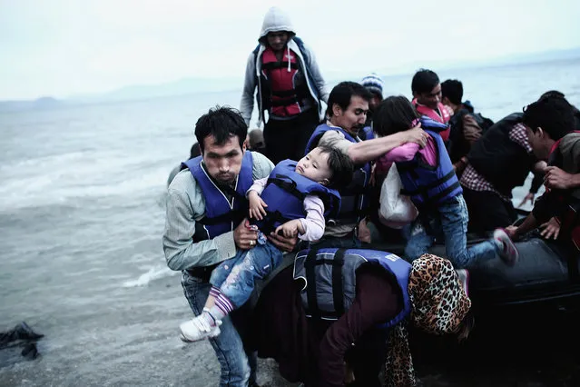 Professional current affairs category winner. In Search of the European Dream, by Angelos Tzortzinis, Greece. An Afghan refugee carries his child as he arrives on a beach on the Greek island of Kos, in May 2015, after crossing a part of the Aegean Sea between Turkey and Greece. (Photo by Angelos Tzortzinis/AFP Photo)