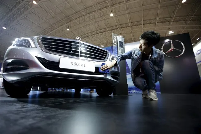 A staff member cleans a Mercedes-Benz S500 eL plug-in hybrid car during the Auto China 2016 in Beijing, China, April 25, 2016. (Photo by Jason Lee/Reuters)