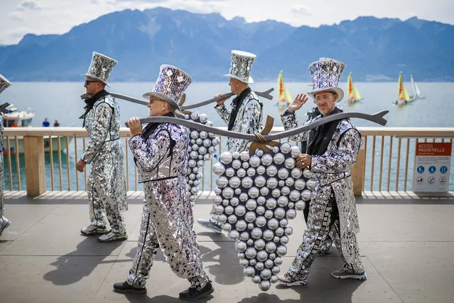 Extras of the “Fete des Vignerons” (winegrowers' festival) march during the official opening parade prior to the first representation and crowning ceremony in Vevey, Switzerland, 18 July 2019. Organized in Vevey by the brotherhood of winegrowers since 1979, the event will celebrate winemaking from July 18 to August 11 this year. (Photo by Valentin Flauraud/EPA/EFE)