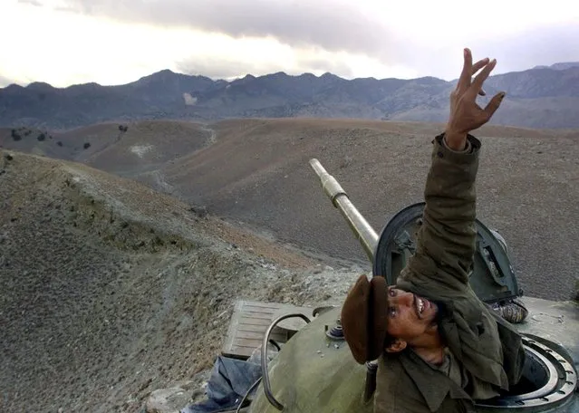In this December 10, 2001 file photo, an Afghan anti-Taliban fighter pops up from his tank to spot a U.S. warplane bombing al-Qaida fighters in the White Mountains of Tora Bora in Afghanistan. Anti-Taliban forces and U.S. warplanes continued to hit the Tora Bora mountains and the al-Qaida fighters occupying the area. (Photo by David Guttenfelder/AP Photo/File)