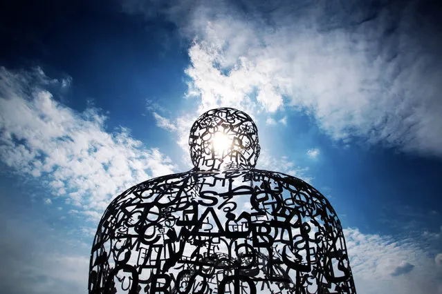 The sun shines through the sculpture “Body of Knowledge” (2010) by Spanish artist Jaume Plensa on the Johann Wolfgang Goethe University campus in Frankfurt am Main, Germany, May 14, 2015. (Photo by Fredrik von Erichsen/EPA)