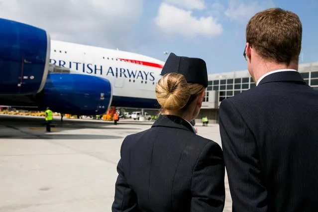 British Airways cabin crew members greet a BA Airbus A380 Super Jumbo at the terminal of Dulles International Airport, Virginia, USA on 2nd October, 2014. (Photo by Kristoffer Tripplaar/Alamy Stock Photo )
