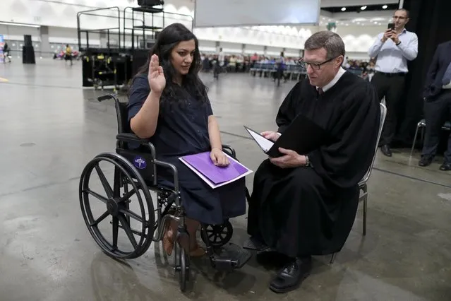 Tatev, 31, (L) who is from Armenia and has lived in the U.S. for 17 years, went into labor before her U.S. citizenship ceremony and refused to go to hospital until she was sworn in as a U.S. citizen, according to Judge Cormac J. Carney who is seen performing a quick impromptu naturalization ceremony before the official event in Los Angeles, California, U.S., August 22, 2019. (Photo by Lucy Nicholson/Reuters)